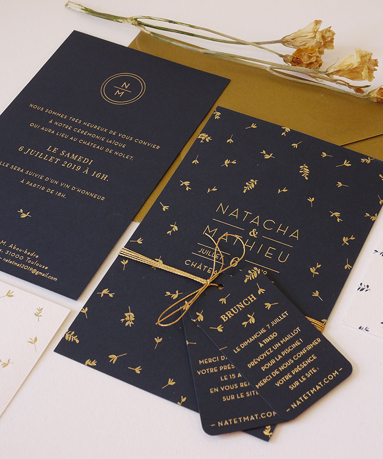 Invitation de mariage fleurie en doré sur papier bleu marine