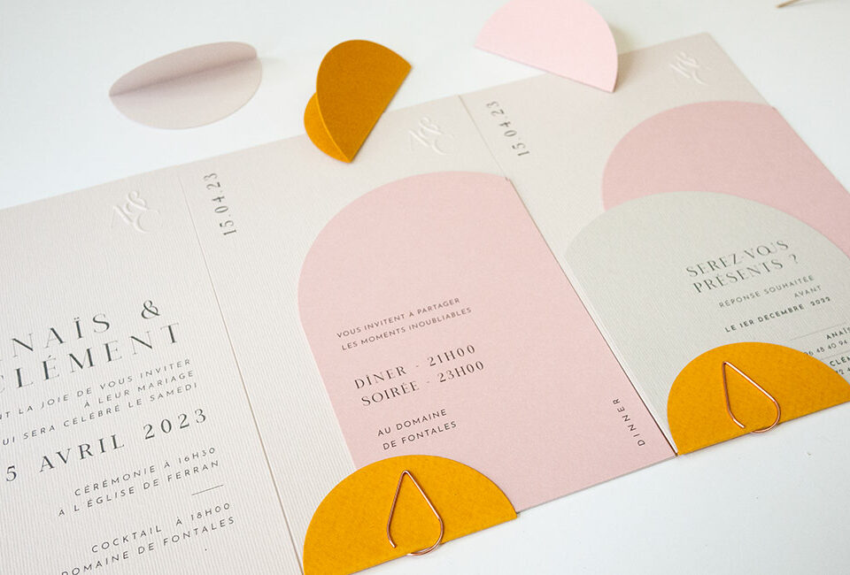 Faire-part de mariage moderne en rose poudré avec gaufrage artisanal et petit cercle jaune vif, création contemporaine signée Poppypress à Toulouse.